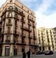 Una casa de principios del siglo XX y, al fondo, un edificio moderno, en la calle Pere IV