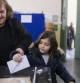 Una mujer con una niña depositan un voto en una urna de un colegio electoral de Atenas.