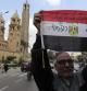 Un hombre sostiene una bandera egipcia mientras protesta por el asesinato ayer de una veintena de coptos egipcios en Libia por los yihadistas del grupo Estado Islámico (EI), ante la Catedral copta de San Marcos en El Cairo