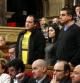 Los tres diputados de la CUP, de pie escuchando la respuesta del conseller de Interior