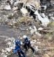 Fotografía facilitada por el Ministerio francés del Interior, que muestra a dos miembros de los servicios de rescate mientras examinan los restos del avión siniestrado
