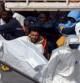 Los equipos de emergencias cargan con el cuerpo de un fallecido en el rescate a una embarcación con inmigrantes a la deriva en Malta