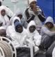 Inmigrantes aguardan en un guardacostas italiano el momento de ser desembarcados en el puerto de Catania (Sicilia)