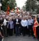 Cientos de personas portando banderas nacionales cantan el himno nacional frente a una estación de policía en Skopje