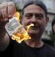 Unos griegos queman un billete de cinco euros en señal de protesta