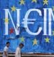 Hombres pasean frente a un grafiti recien pintado en el que se puede leer la palabra "no" en Atenas, Grecia, el 28 de junio de 2015