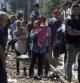Cientos de inmigrantes esperan en una estación de tren en Macedonia un tren que les llevará a Serbia, donde caminarán hasta la frontera con Hungría