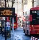 Un típico autobús londinense de dos plantas pasa junto a un cartel en el que se anuncia el alto riesgo de contagio y se pide a los ciudadanos que tomen precauciones ante la expansión del coronavirus