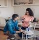 Couple coloring a chair at their living room.
