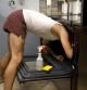 male stands in boxers trying to clean a stove