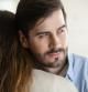 Thoughtful young man hug girlfriend or wife look in distance thinking pondering about relationship problems, millennial male liar or cheater make peace with beloved woman, fake forgiveness