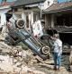 FILE - In this file photo dated Monday, July 19, 2021, a woman looks at cars and homes damaged after torrential rain caused flooding in Liege, Belgium. A new massive United Nations science report is scheduled for release Monday Aug. 9, 2021, reporting on the impact of global warming due to humans. (AP Photo/Valentin Bianchi, FILE)