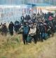 TOPSHOT - A group of migrants moves along the Belarusian-Polish border towards a camp to join those gathered at the spot and aiming to enter EU member Poland, in the Grodno region on November 12, 2021. - Hundreds of desperate migrants are trapped in freezing temperatures on the border and the presence of troops from both sides has raised fears of a confrontation. (Photo by Leonid Shcheglov / BELTA / AFP) / Belarus OUT