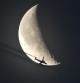 La luna menguante atravesada por un avión, vista desde Gavà.