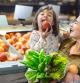 Una niña comiendo una manzana junto a su madre