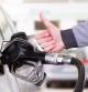 Petrol or gasoline being pumped into a motor vehicle car. Closeup of man, showing thumb up gesture, pumping gasoline fuel in car at gas station. (Petrol or gasoline being pumped into a motor vehicle car. Closeup of man, showing thumb up gesture, pumpi