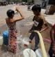A boy bathes as he waits to collect water from a municipal tanker on a hot summer day in New Delhi, India, May 1, 2022. REUTERS/Anushree Fadnavis