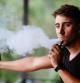 Un joven vapeando con un cigarrillo electrónico