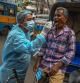 TOPSHOT - Health workers collect swab samples from commuters for Covid-19 coronavirus screening after a surge in number infections in Kolkata on July 4, 2022. (Photo by DIBYANGSHU SARKAR / AFP)