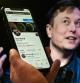 In this photo illustration, a phone screen displays the Twitter account of Elon Musk with a photo of him shown in the background, on April 14, 2022, in Washington, DC. - Tesla chief Elon Musk has launched a hostile takeover bid for Twitter, insisting it was a 