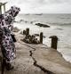 A woman looks down a newly formed crack in the walk way which leads to the Mosque in Bargny on September 18, 2020. - Fishing villages like Bargny have been fighting the rising seas for decades, hundreds of houses have been lost and families displaced. Through the months of July to September, peaking at the equinox, coastal towns like Bargny must brace for the worst, tides are at their highest, rising every year, storms are more frequent, battering the coastline which speeds up the erosion. (Photo by JOHN WESSELS / AFP)