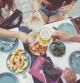 Tourists in Barcelona eating tapas in a typical restaurant in the Barri Gotic. On the table a travel guide of Spain and a smartphone.