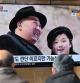 People watch a television screen showing a news broadcast with an image of North Korean leader Kim Jong Un (L) and his daughter presumed to be named Ju Ae (R) attending a military parade held in Pyongyang to mark the 75th founding anniversary of its armed forces, at a railway station in Seoul on February 9, 2023. - North Korea's Kim Jong Un oversaw a major military parade showcasing a record number of nuclear and intercontinental ballistic missiles, state media reported on February 9, including what analysts said was possibly a new solid-fueled ICBM. (Photo by Jung Yeon-je / AFP)