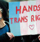 A Trans Rights activist holds a placard while taking part in the 