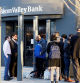 FILE PHOTO: FDIC representatives Luis Mayorga and Igor Fayermark speak with customers outside of the Silicon Valley Bank headquarters in Santa Clara, California, U.S. March 13, 2023. REUTERS/Brittany Hosea-Small/File Photo
