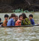 A man (L) along with a youth use a satellite dish to move children across a flooded area after heavy monsoon rainfalls in Jaffarabad district, Balochistan province, on August 26, 2022. - Heavy rain continued to pound parts of Pakistan on August 26 after the government declared an emergency to deal with monsoon flooding it said had 