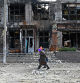 TOPSHOT - Local residents walks in front of a destroyed store in the Tsirkuny village, Kharkiv region, amid the Russian invasion of Ukraine. (Photo by SERGEY BOBOK / AFP)