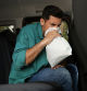 Man with paper bag suffering from nausea in car