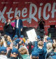 Participants attend the meeting of leftist party PVDA - PTB, with a banner reading 'Tax the rich' in the background in Brussels, on Labour Day, the International Workers' Day, on May 1, 2023. (Photo by HATIM KAGHAT / Belga / AFP) / Belgium OUT