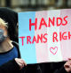 A Trans Rights activist holds a placard while taking part in the