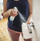 Woman cleaning a door handle with a disinfection spray and disposable wipe. Woman sanitizing door handle with antibacterial spray. Girl staying at home during coronavirus outbreak