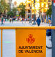 Valencia, Spain - April 15, 2022: A metallic barrier with the coat of arms of the city is seen in the old town. Incidental people walk in the background.