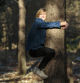 young blond boy hugging a tree in the sunlight