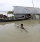 A man walks through flood waters to collect drinking water at Faridpur on July 19, 2020. (Photo by STR / AFP) /