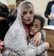 TOPSHOT - An injured Palestinian woman covered in dust and blood hugs an injured girl child at the hospital following the Israeli bombardment of Khan Yunis in the southern Gaza Strip on November 15, 2023, amid the ongoing battles between Israel and the Palestinian group Hamas. More than 11,000 people have been killed in relentless Israeli bombardment of the Gaza Strip, according to the Hamas-run health ministry, since the war erupted after Palestinian militants raided southern Israel on October 7 killing at least 1200 people, according to official Israeli figures. (Photo by Belal KHALED / AFP)
