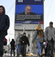 People walk past an electronic billboard on a building showing Russian President Vladimir Putin as he gives his annual state-of-the-nation address in Moscow, Russia, on Thursday, Feb. 29, 2024. (AP Photo/Dmitry Serebryakov)