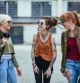 Three female friends, living alternative lifestyle, going together to skate park or music festival. Redhead, blonde and girl with dreadlocks and tattoos sharing moments.