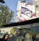 A woman walks past an anti-Israeli banner on a building at the Felestin (Palestine) Square in downtown Tehran, Iran, Sunday, April 14, 2024. Israel on Sunday hailed its air defenses in the face of an unprecedented attack by Iran, saying the systems thwarted 99% of the more than 300 drones and missiles launched toward its territory. The sign in Hebrew reads: 