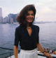 (Original Caption) The familiar towers of Manhattan and the not unknown physiognomy of Jacqueline Kennedy Onassis can be made out in the New York Harbor, as she returns to the Big Apple from Staten Island, where she toured the Snug Harbor Cultural Center.