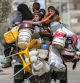 TOPSHOT - A man, woman, and children ride in the back of a tricycle loaded with belongings and other items as they flee bound for Khan Yunis, in Rafah in the southern Gaza Strip on May 11, 2024 amid the ongoing conflict in the Palestinian territory between Israel and Hamas. (Photo by AFP)