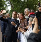 TOPSHOT - France's President Emmanuel Macron (C) takes a selfie photograph with supporters after casting his vote in the second round of France's legislative election at a polling station in Le Touquet, northern France on July 7, 2024. France votes in legislative elections on July 7, 2024 that will be decisive in determining its political future and could see the far right become the largest party in parliament for the first time. (Photo by MOHAMMED BADRA / POOL / AFP)