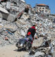 A Palestinian man assists a woman in a wheelchair past the rubble of a house destroyed in the Israel's military offensive, amid the Israel-Hamas conflict, in Khan Younis, in the southern Gaza Strip, September 26, 2024. REUTERS/Hatem Khaled