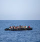 Migrants wait to be rescued by Italian coast guard in the Mediterranean Sea, 30 nautic miles from the Libyan coast, on August 6, 2017. / AFP PHOTO / ANGELOS TZORTZINIS
