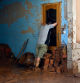 TOPSHOT - A man leans on a broken door to take a breather on cleaning on November 1, 2024, following the devastating effects of flooding on the town of Paiporta, in the region of Valencia, eastern Spain. The death toll from Spain's worst floods in a generation has climbed to 205, rescuers said today, with the number expected to rise as more people are believed missing. The agency coordinating emergency services in the eastern Valencia region said 202 people had been confirmed dead there, with officials in Castilla-La Mancha and Andalusia previously announcing a combined three deaths in their regions. (Photo by JOSE JORDAN / AFP)