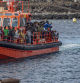 Decenas de migrantes a su llegada al Puerto de la Restinga, a 26 de noviembre de 2024, en El Hierro, Santa Cruz de Tenerife, Tenerife, Canarias (España). Esta mañana, el helicóptero de salvamento marítimo, Helimer, con base en Santa Cruz de Tenerife, localizaba un cayuco a 35 millas náuticas de la isla de El Hierro. Desde el CCS de Tenerife se activó a la embarcación de SSMM, Salvamar Acrux, que logró rescatar a 165 personas migrantes, entre las que se encontraban 20 mujeres y 2 niños pequeños, que fueron trasladadas hasta el puerto de La Restinga donde fueron desembarcadas. Entre las personas se encontraban ciudadanos yemeníes además de senegaleses y malienses.