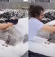 El padre limpiando los restos de nieve de su vehículo con el bebé